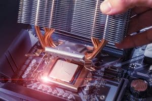 A technician installs an aluminum air-cooled heatsink on a desktop PC CPU. Air Cooler CPU. PC assembly and modernization